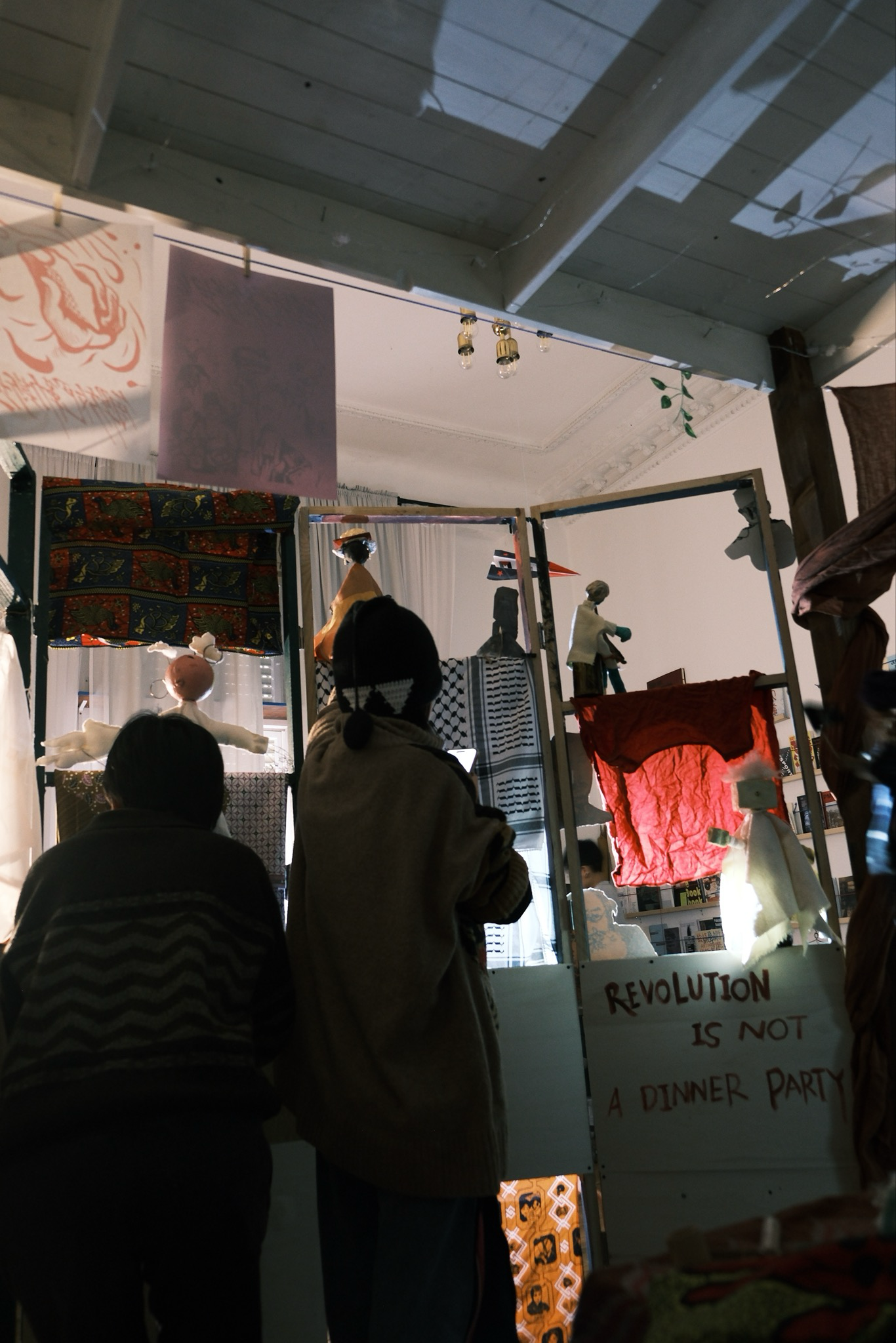 Audience gathered around a puppet theatre installation