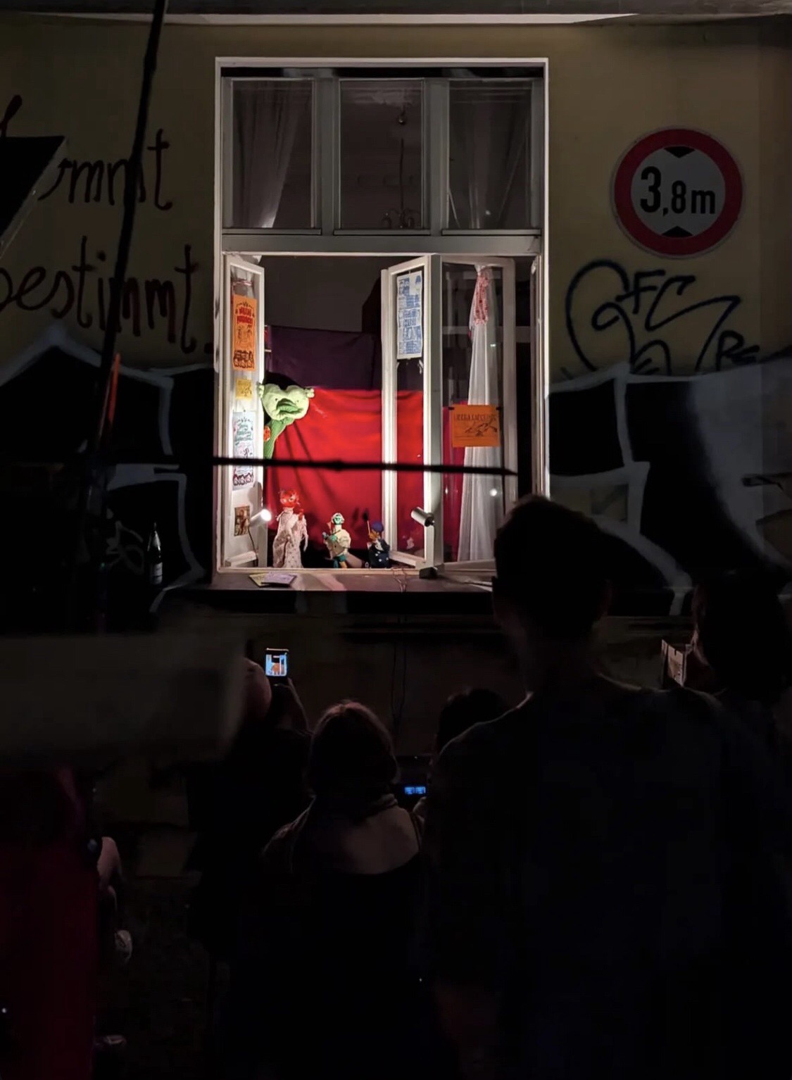 Audience watching a puppet performance in a window